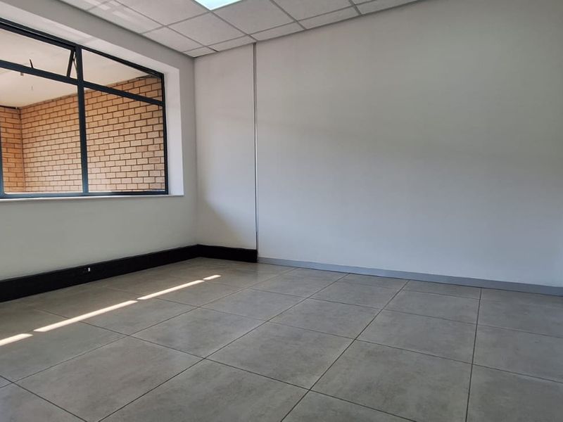 A bright, empty office space featuring large windows, modern tiled flooring, and a clean, neutral finish, ready for professional fit-out.