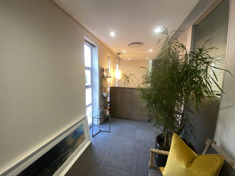 A professional office space featuring carpet tile flooring, recessed downlighting, and a partition wall, creating a functional and well-lit work environment.