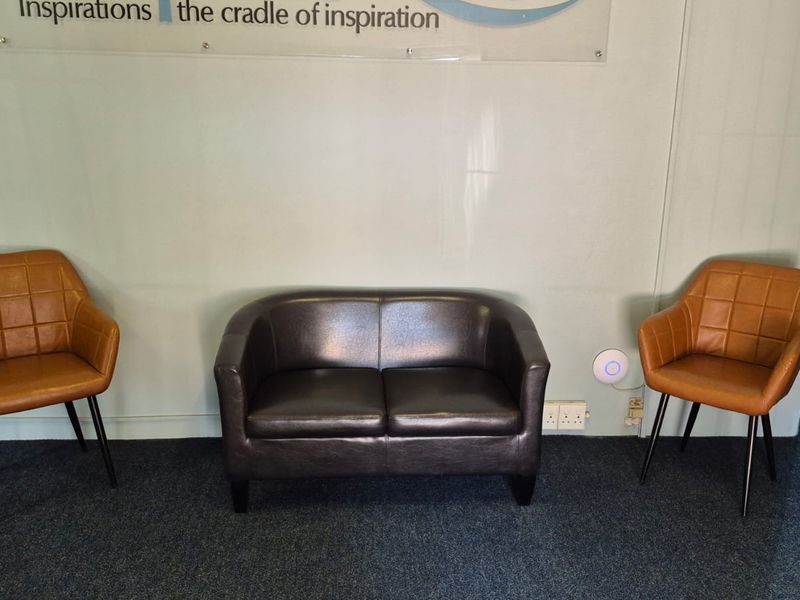 A functional entry or reception area featuring carpeted flooring, wall-mounted signage, and essential safety equipment.