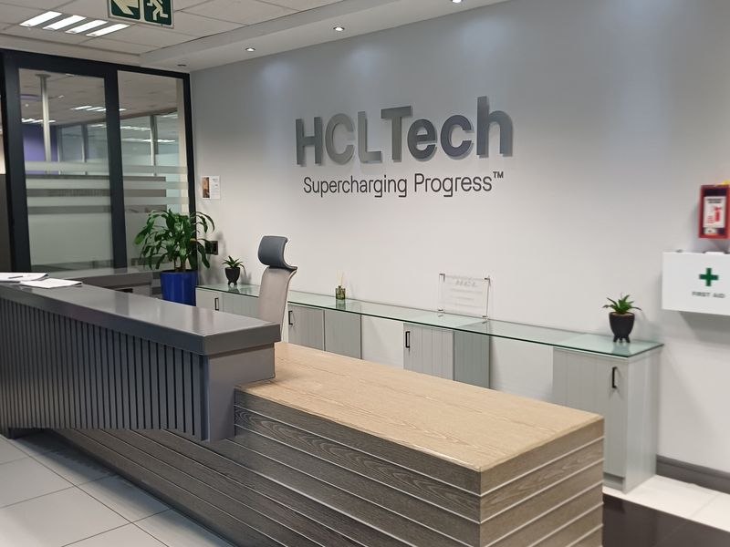Professional office reception area featuring a modern built-in desk, glass partitions, and clean, well-maintained finishes.