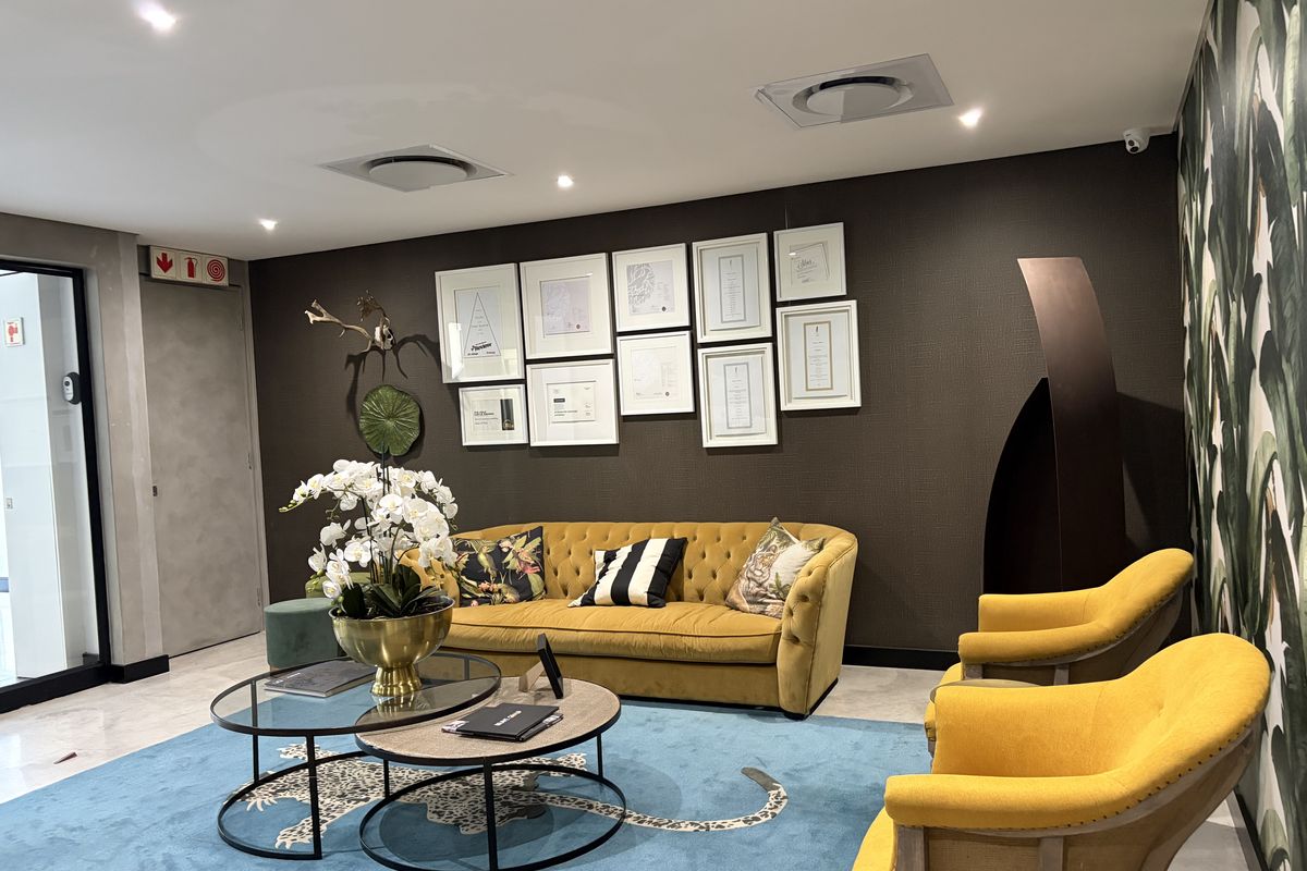 A well-maintained commercial reception or lounge area featuring recessed lighting, air conditioning vents, and modern textured wall finishes.