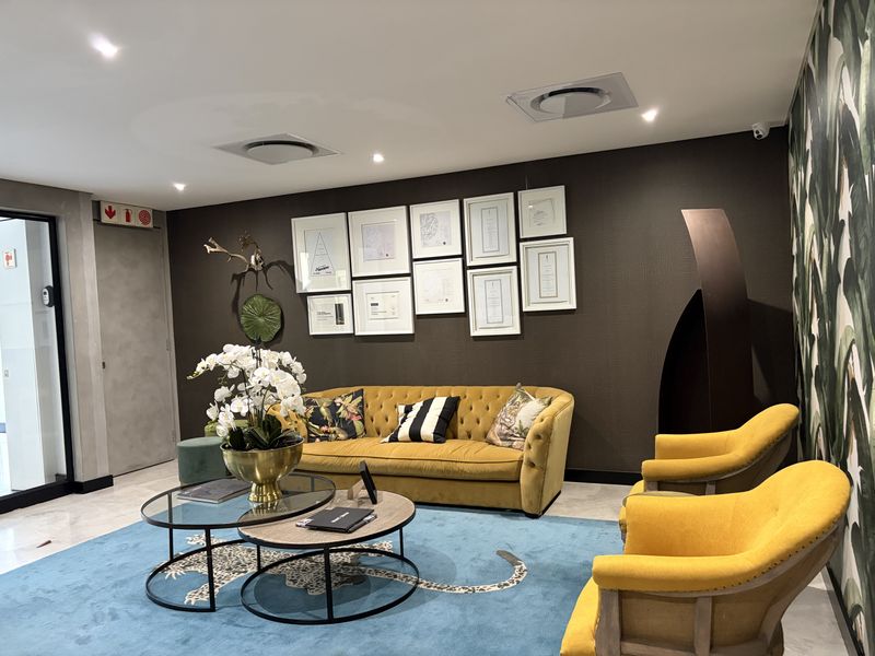 A well-maintained commercial reception or lounge area featuring recessed lighting, air conditioning vents, and modern textured wall finishes.