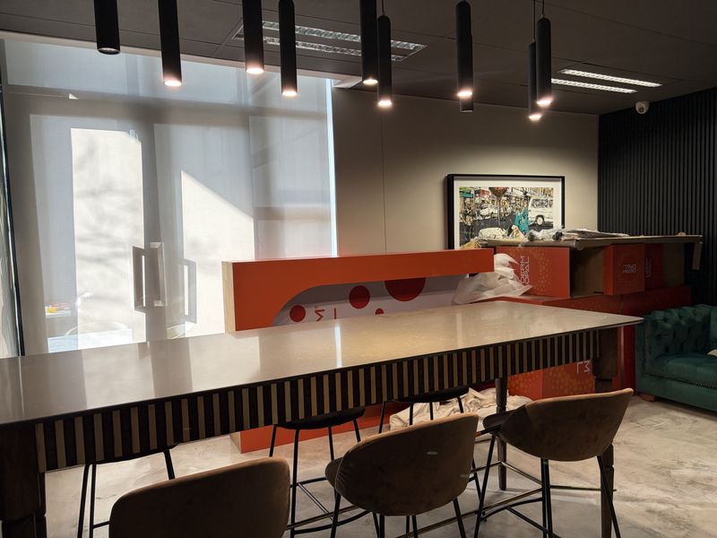 Modern commercial office space featuring contemporary pendant lighting, a stone-topped counter, and stylish slatted wall paneling.
