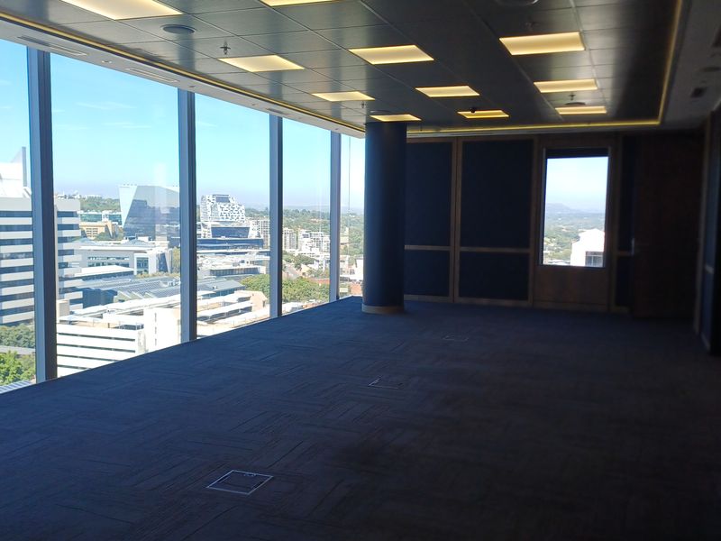 Spacious, modern empty office suite featuring floor-to-ceiling windows with expansive city views, recessed lighting, and high-quality carpeted flooring.