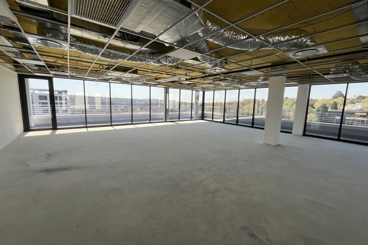 Spacious open-plan office shell featuring floor-to-ceiling windows, panoramic views, and exposed ceiling infrastructure, ready for custom fit-out and interior design.