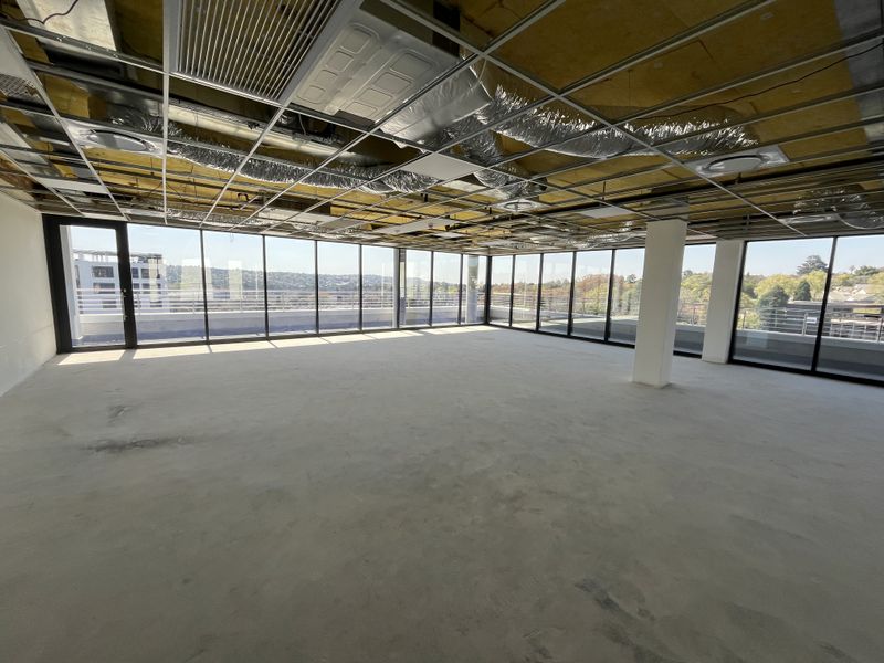 Spacious open-plan office shell featuring floor-to-ceiling windows, panoramic views, and exposed ceiling infrastructure, ready for custom fit-out and interior design.