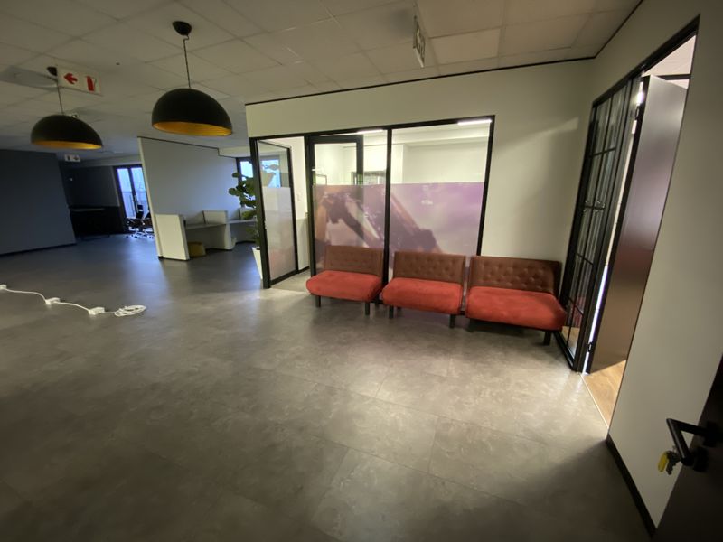 Modern office reception area featuring contemporary glass partitioning, neutral floor tiling, and professional suspended ceiling finishes.