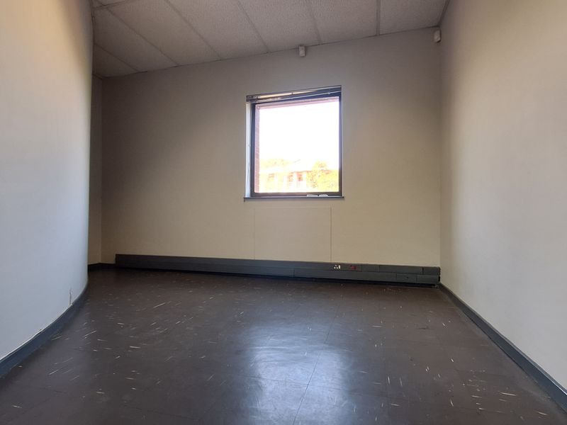 A vacant office space featuring vinyl flooring, a suspended ceiling, and perimeter electrical trunking, offering a blank canvas for professional use.