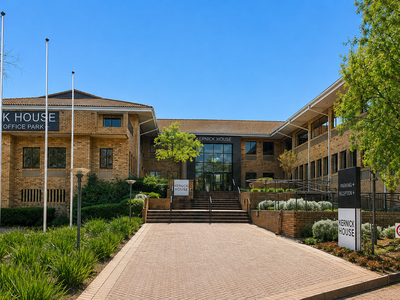 Front elevation of Kernick House office building featuring a brick facade, paved entrance driveway, and landscaped garden area.