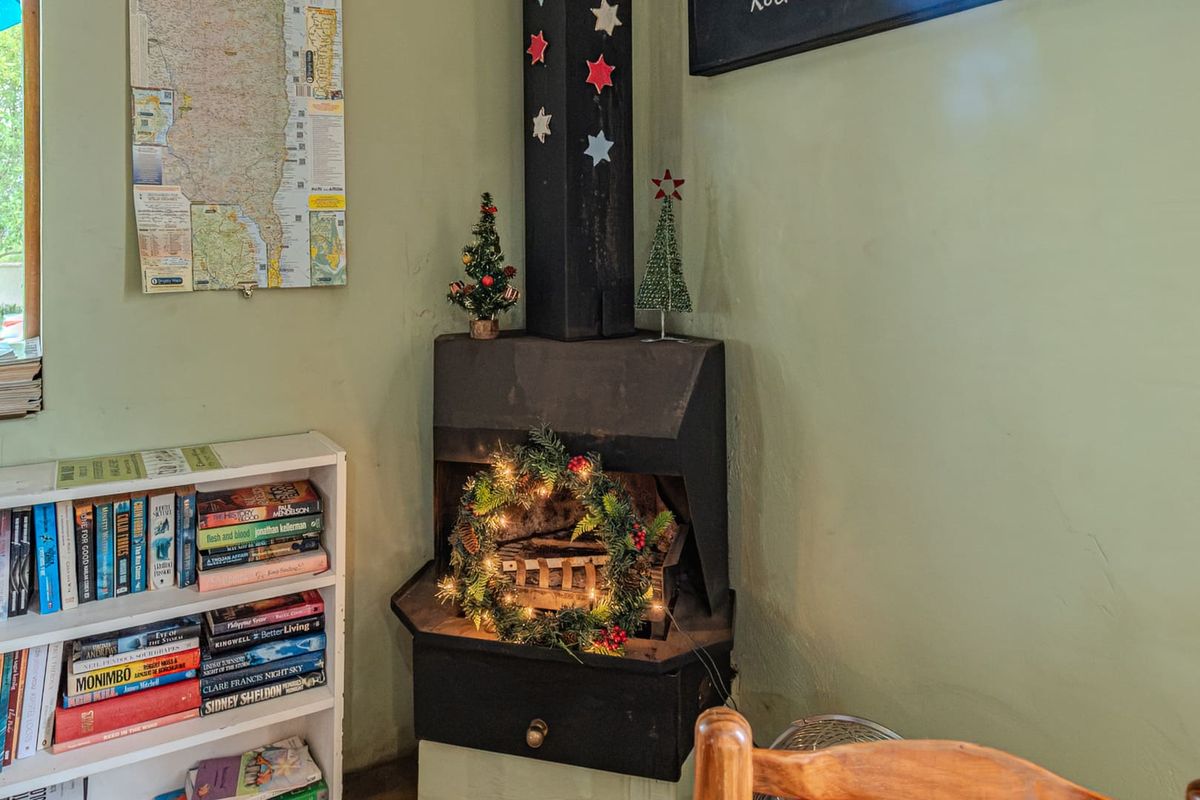 A corner view featuring a built-in metal fireplace with a chimney flue, set against a painted wall in a cozy interior space.