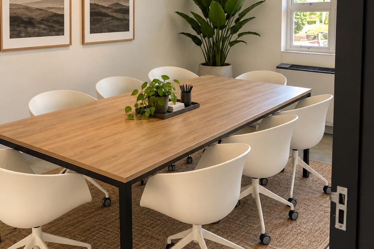 A well-maintained professional office meeting room featuring polished concrete floors, an arched window, and recessed ceiling lighting.