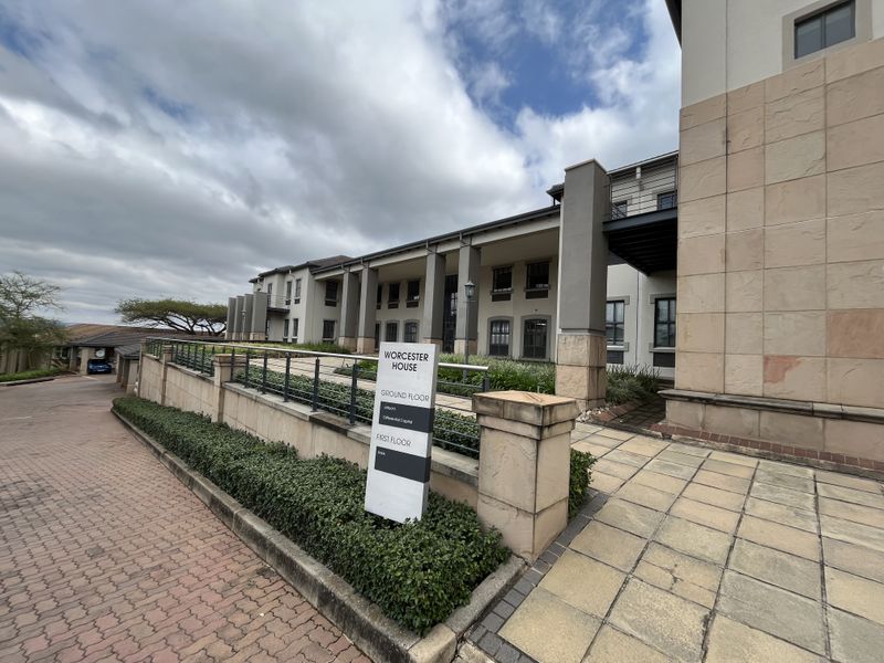 Exterior view of Worcester House office building featuring stone cladding, paved walkways, and professional signage in a well-maintained landscaped setting.