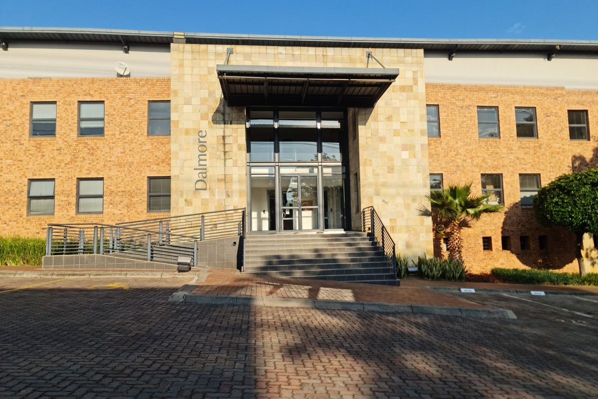 Front elevation of the Dalmore office building featuring a brick and stone facade, glass entrance, and accessible ramp.