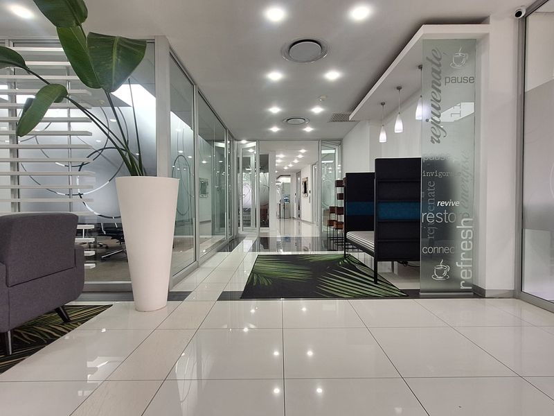 Modern office lobby area featuring polished porcelain flooring, glass partition walls, and professional recessed lighting, creating a bright and contemporary corporate environment.