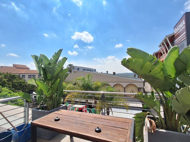 An elevated balcony area featuring stainless steel railings and views of the surrounding urban landscape.