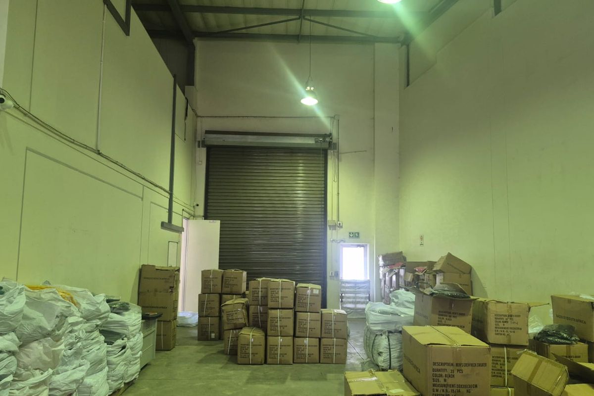 Industrial warehouse unit featuring high ceilings, concrete flooring, and a large roller shutter door for efficient loading and access.