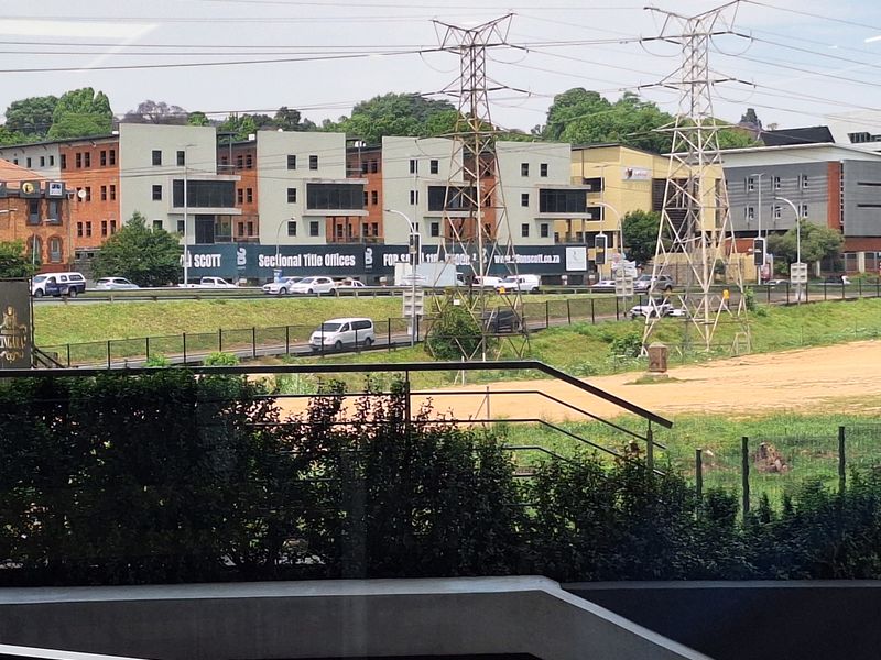 An elevated view overlooking a commercial office park area with power lines and surrounding infrastructure.