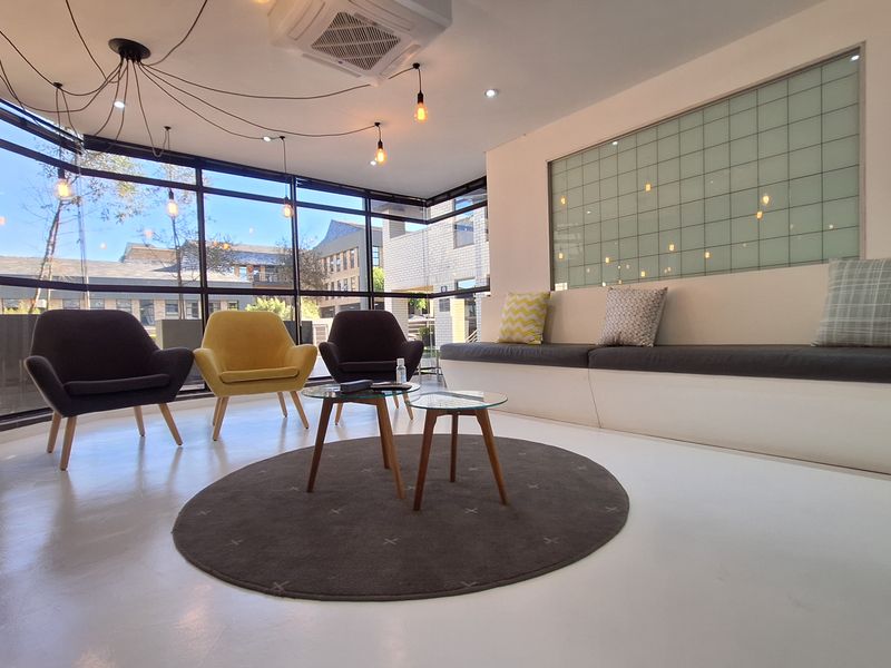 Modern office reception or breakout area featuring floor-to-ceiling windows, built-in bench seating, and a sleek, minimalist design with integrated climate control.