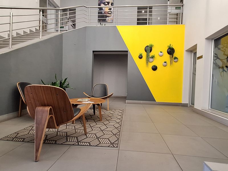 Modern office entrance foyer featuring a staircase with stainless steel balustrades and contemporary tiled flooring.