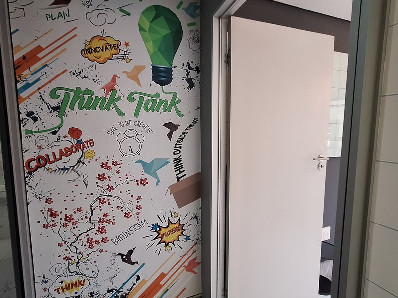 An office entrance featuring a creative graphic wall design and a standard internal door leading into a workspace.
