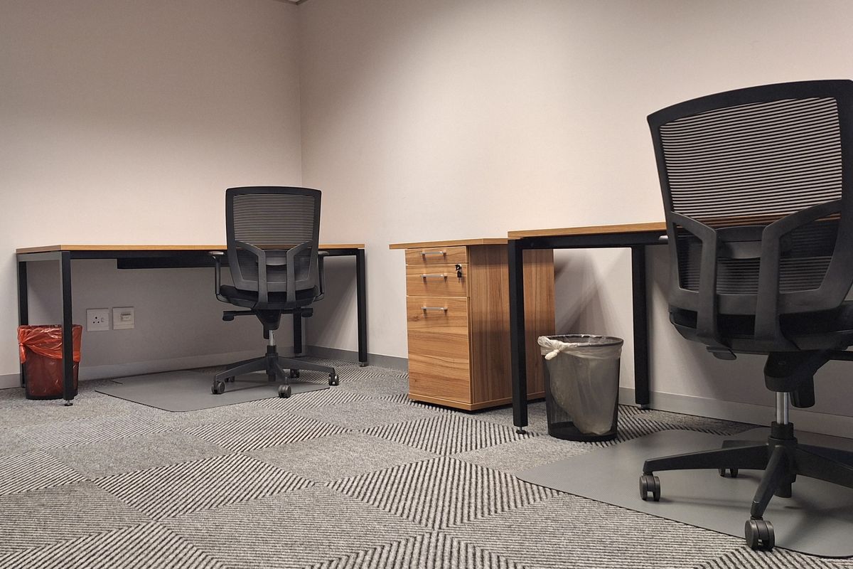 A functional office space featuring carpet tile flooring, integrated electrical and data connectivity, and a clean, professional layout.