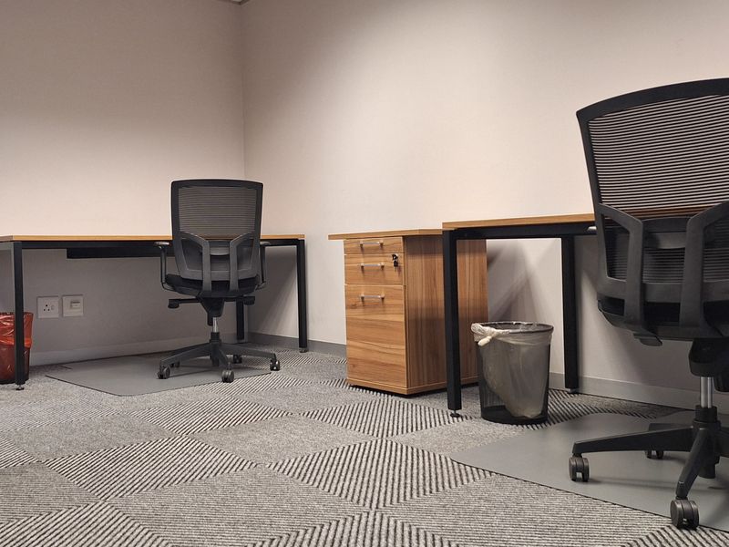 A functional office space featuring carpet tile flooring, integrated electrical and data connectivity, and a clean, professional layout.