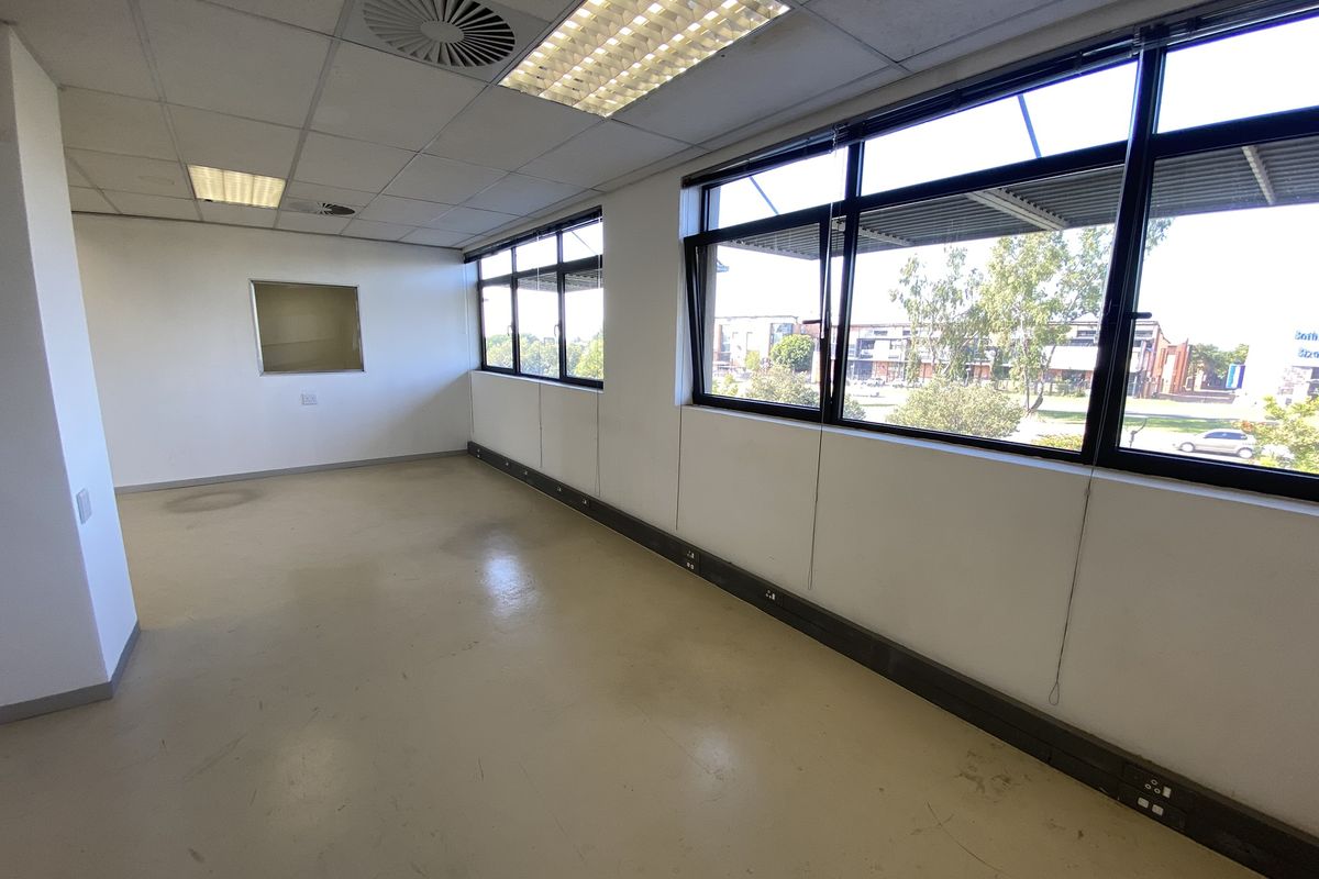 A vacant, open-plan office space featuring large windows, suspended ceilings with recessed lighting, and practical vinyl flooring with integrated electrical trunking.