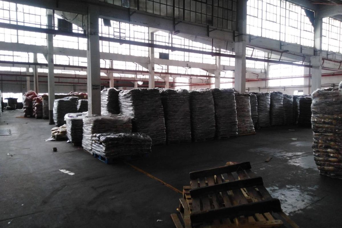 Large industrial warehouse space featuring high ceilings, extensive clerestory windows for natural light, and durable concrete flooring suitable for storage or manufacturing operations.