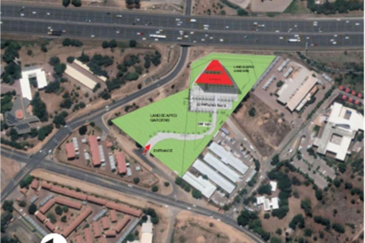 Aerial site plan showing the property layout, including the building footprint, landscaped garden areas, parking bays, and main entrance access.