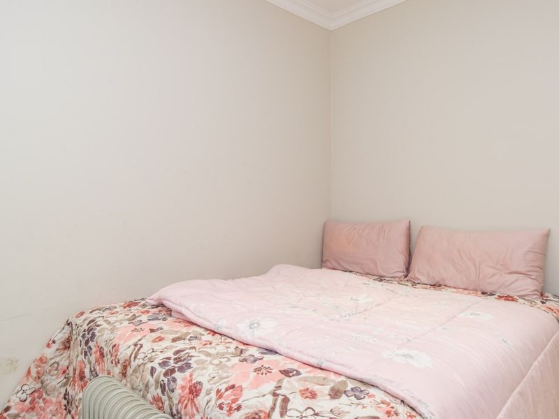 A simple bedroom featuring neutral walls and decorative coving, providing a blank canvas for personalization.
