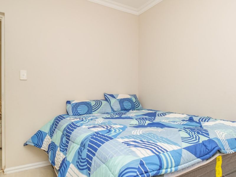 A simple bedroom featuring neutral walls, coving, and skirting boards, providing a clean and functional space.