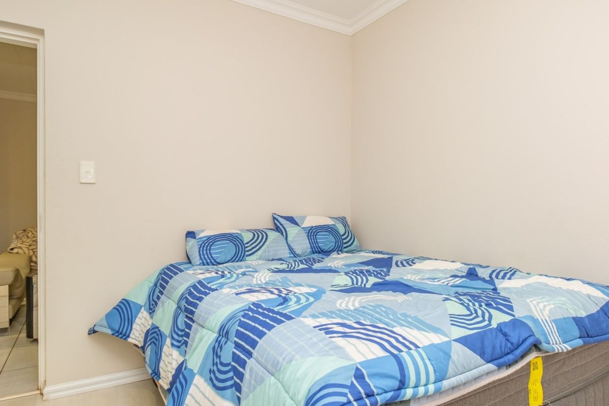 A simple bedroom featuring neutral walls, coving, and skirting boards, providing a clean and functional space.
