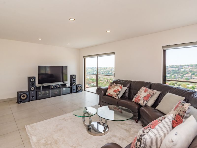 Spacious living room featuring large sliding glass doors that provide natural light and expansive views, complemented by neutral tiled flooring and recessed lighting.