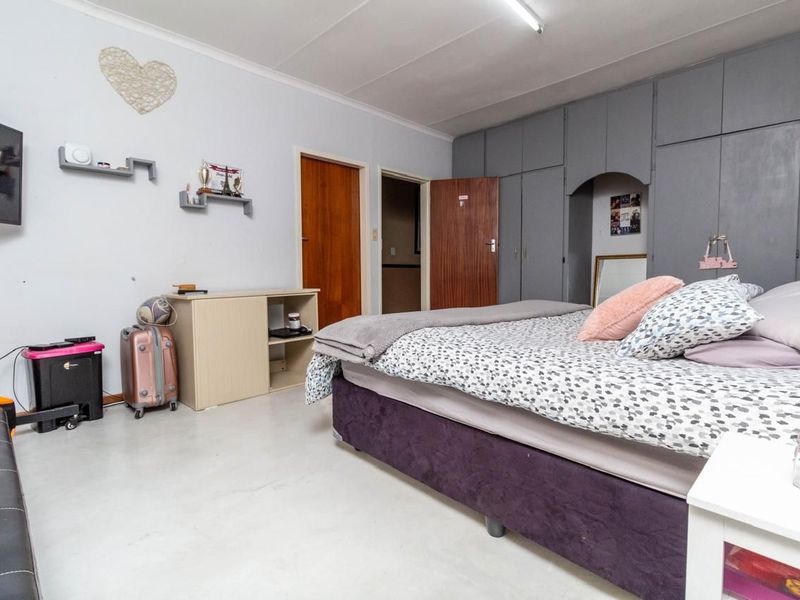 A bedroom featuring built-in cupboards and neutral flooring, offering a functional space with potential for cosmetic updates to enhance the interior aesthetic.