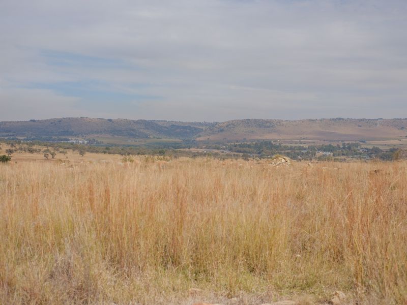 A scenic view of the expansive natural grassland and distant rolling hills, showcasing the open landscape of the vacant residential property.