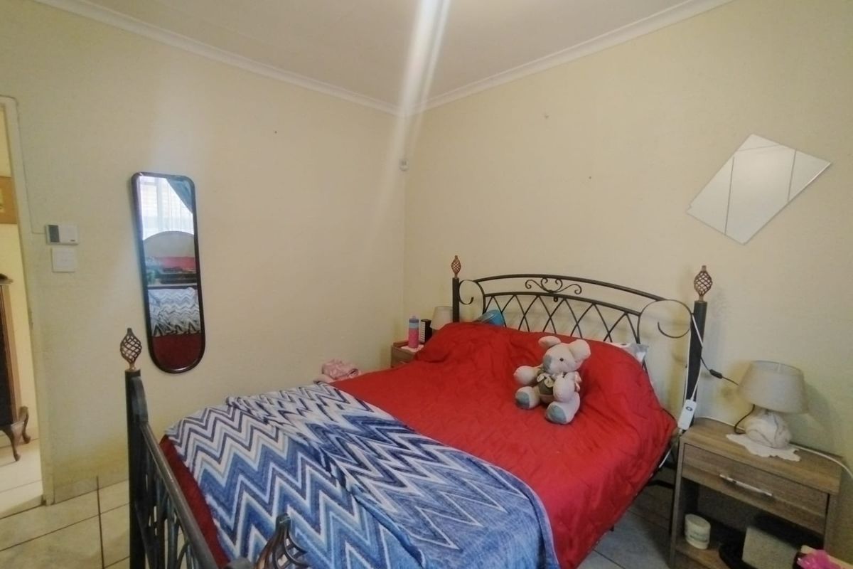 A standard bedroom featuring tiled flooring and coved ceiling finishes, providing a functional space ready for personalization.