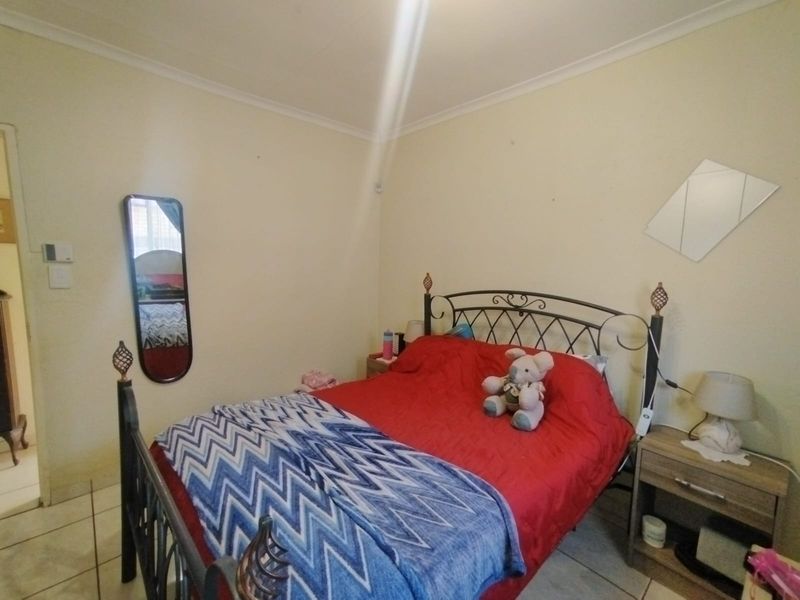 A standard bedroom featuring tiled flooring and coved ceiling finishes, providing a functional space ready for personalization.