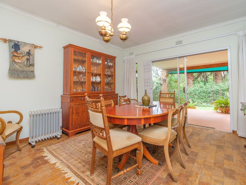 A dining room featuring terracotta tile flooring and a sliding glass door providing direct access to the outdoor patio area.