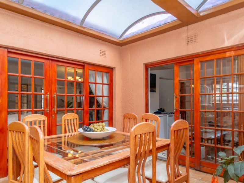 A covered patio area featuring a large skylight and multiple wooden sliding doors providing access to the interior living spaces.