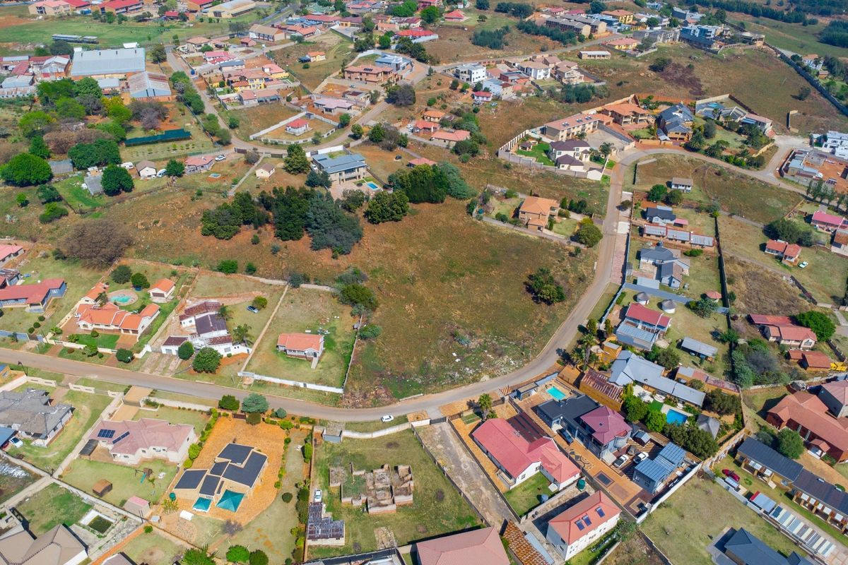 An aerial view of a vacant residential plot situated within an established neighborhood, offering potential for development.