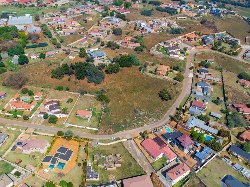 An aerial view of a vacant residential plot situated within an established neighborhood, offering potential for development.
