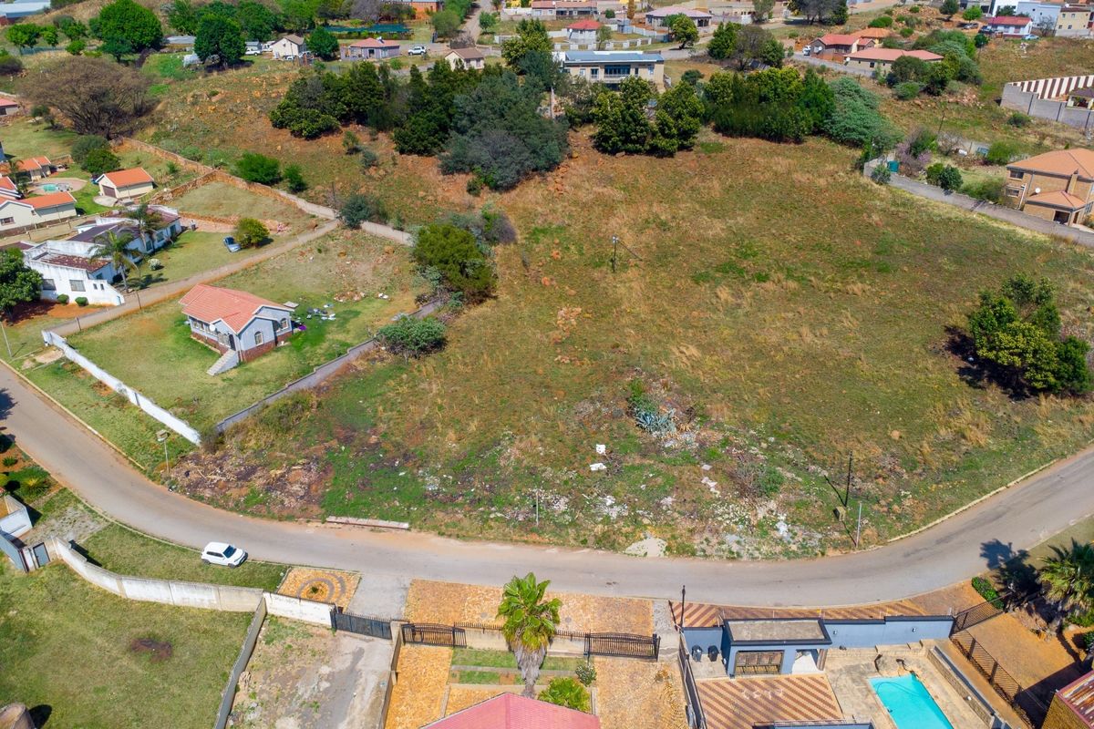 Aerial view of a vacant residential plot situated in a developed neighborhood, offering potential for new construction.