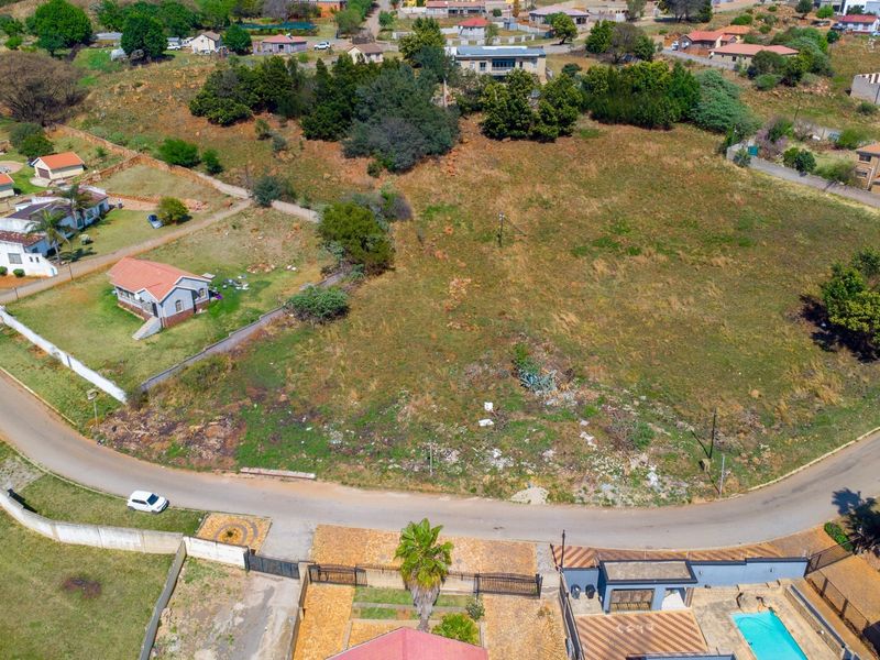 Aerial view of a vacant residential plot situated in a developed neighborhood, offering potential for new construction.