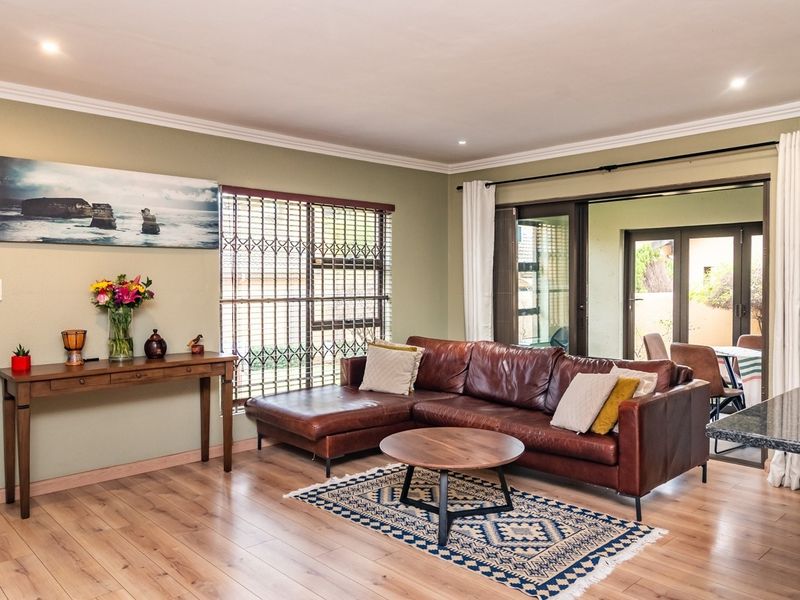 Spacious open-plan living area featuring laminate flooring, recessed lighting, and direct access to the patio through large sliding glass doors.