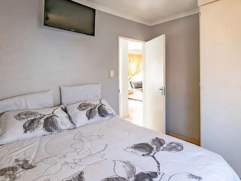 A functional bedroom featuring a built-in wardrobe and neutral wall finishes, providing a comfortable and practical living space.