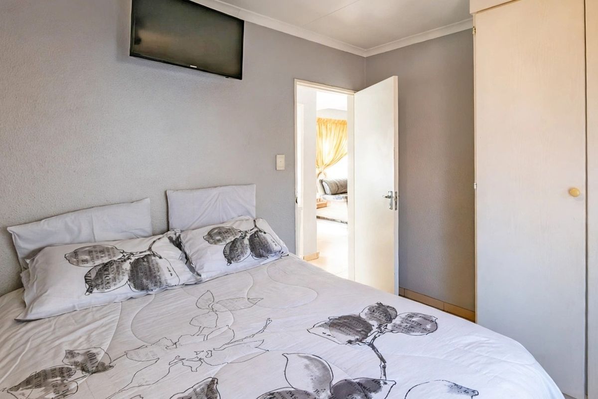 A functional bedroom featuring a built-in wardrobe and neutral wall finishes, providing a comfortable and practical living space.