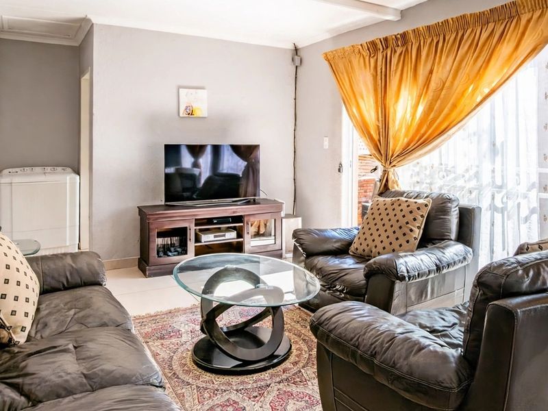 A comfortable living room featuring tiled flooring and a sliding glass door that provides access to the outdoor area.