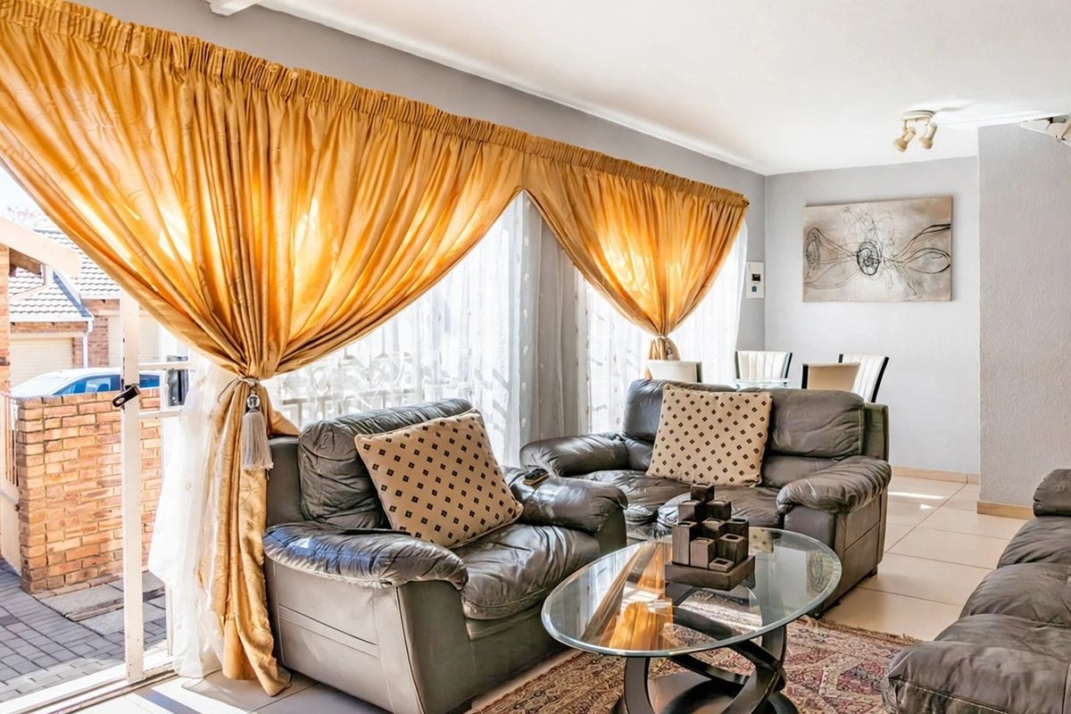 Spacious living area featuring tiled flooring and a large sliding glass door providing access to the outdoor patio area.