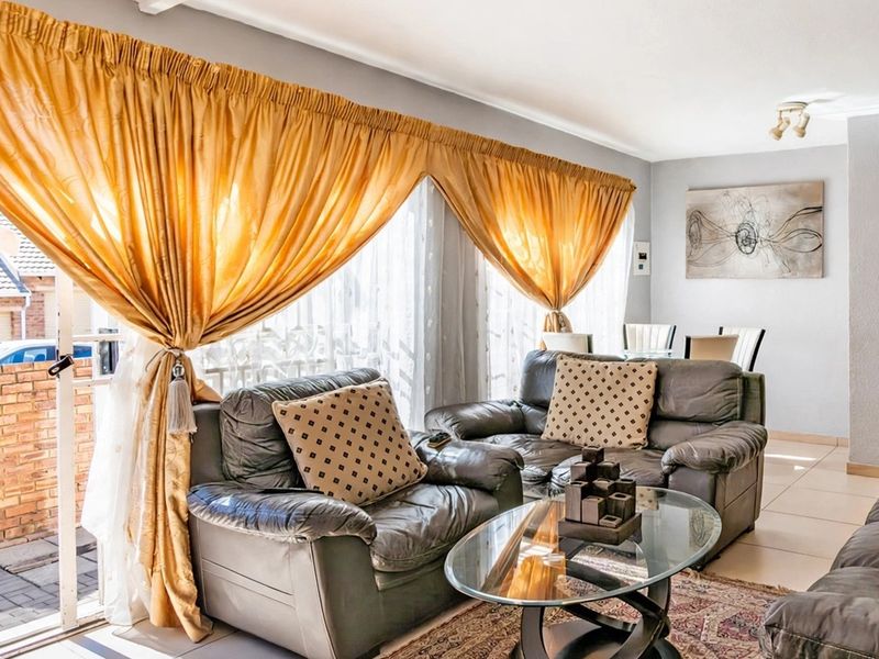Spacious living area featuring tiled flooring and a large sliding glass door providing access to the outdoor patio area.