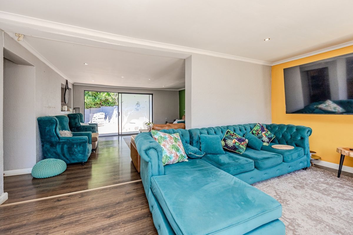 Spacious living area featuring laminate flooring, recessed downlights, and a sliding glass door providing access to the outdoor space.